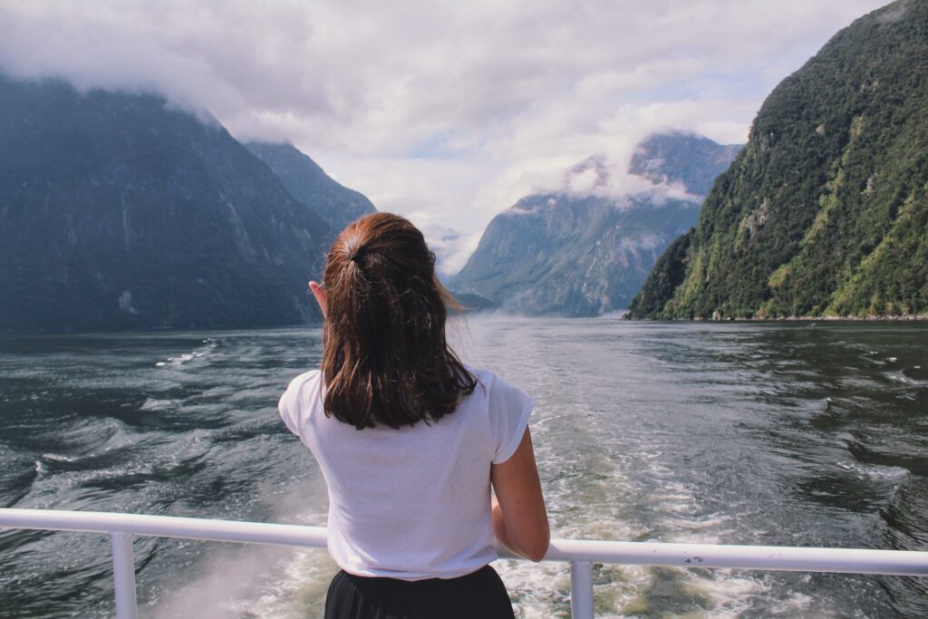 melody on boar in milford sound facing the sea with vast cliffs either side of her
