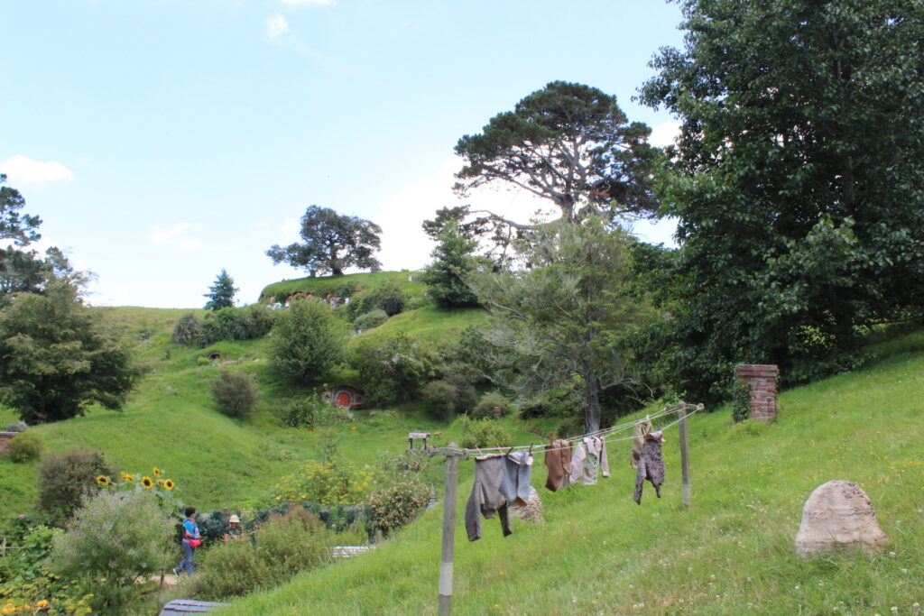 hobbiton, new zealand. hobbit sized clothes line and hobbit holes in the distance