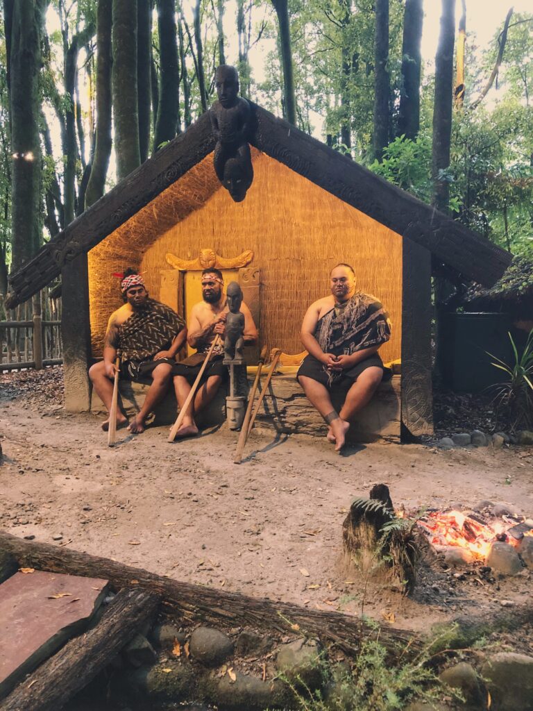 Mitai Maori Village- maori men sitting in shelter