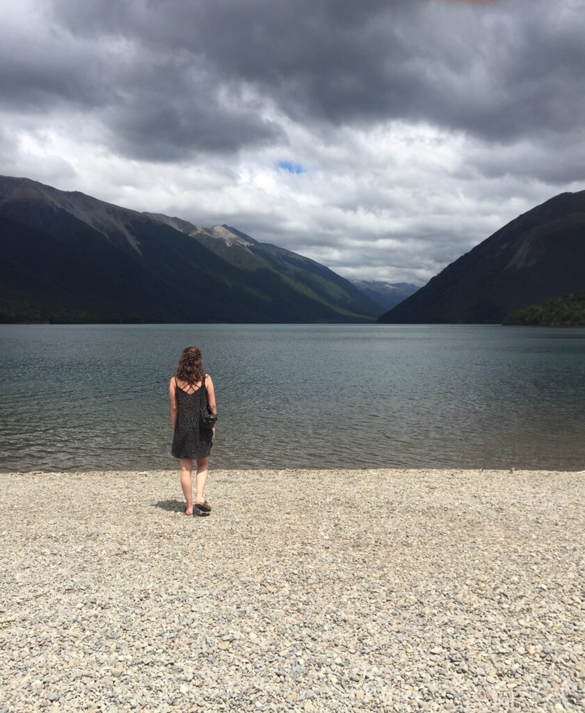 melody walking towards lake with mountains in background in nelson lakes national park, new zealand