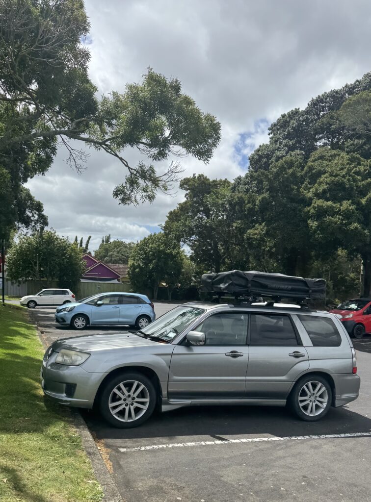 silver 4x4 car with packed away rooftop tent in auckland, new zealand