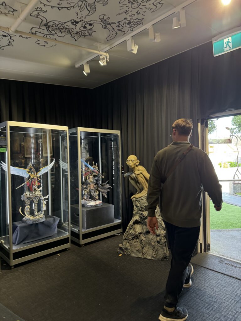 weta workshop in wellington, new zealand. man walking out with gollum statue in background