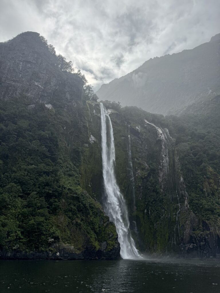 large waterfall in milford sound, new zealand