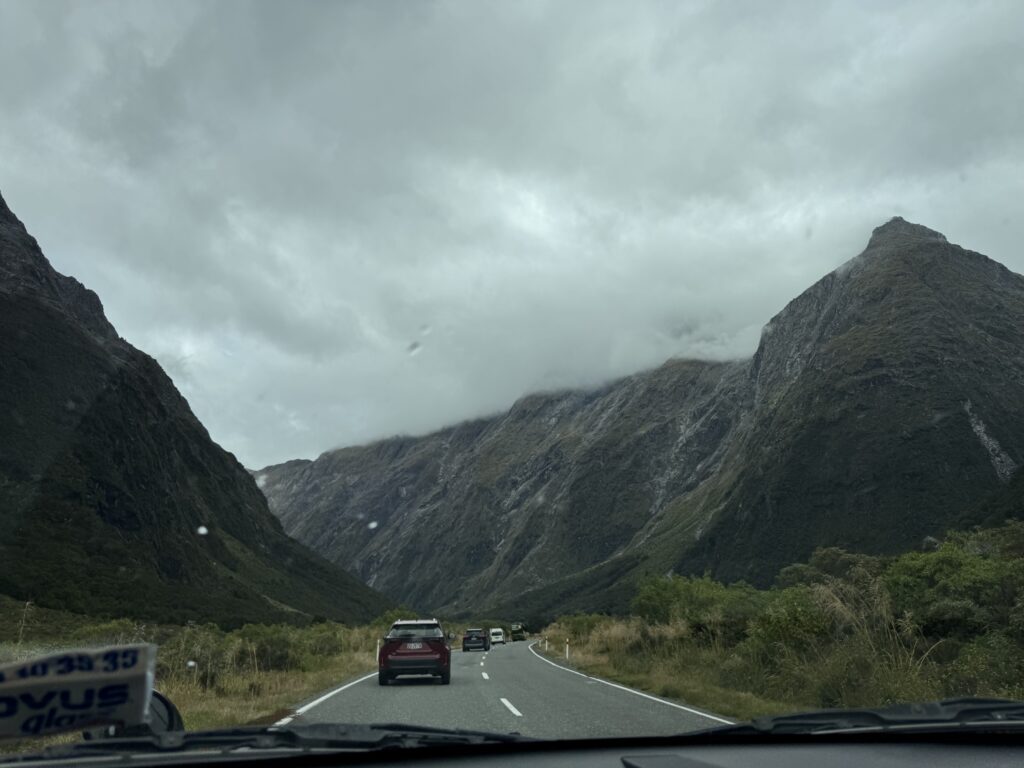 Gertrude Valley Lookout, milford sound, new zealand. cars driving ahead
