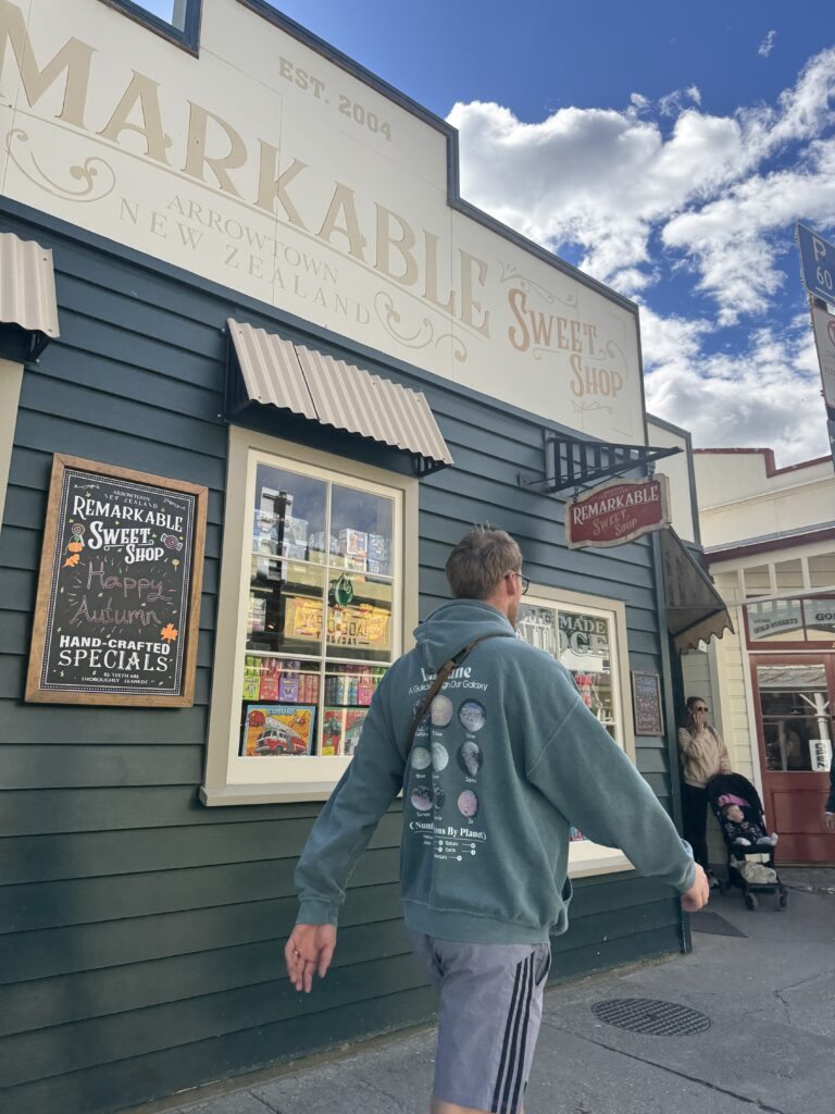 wooden buildings in arrowtown, new zealand. man walking in foreground